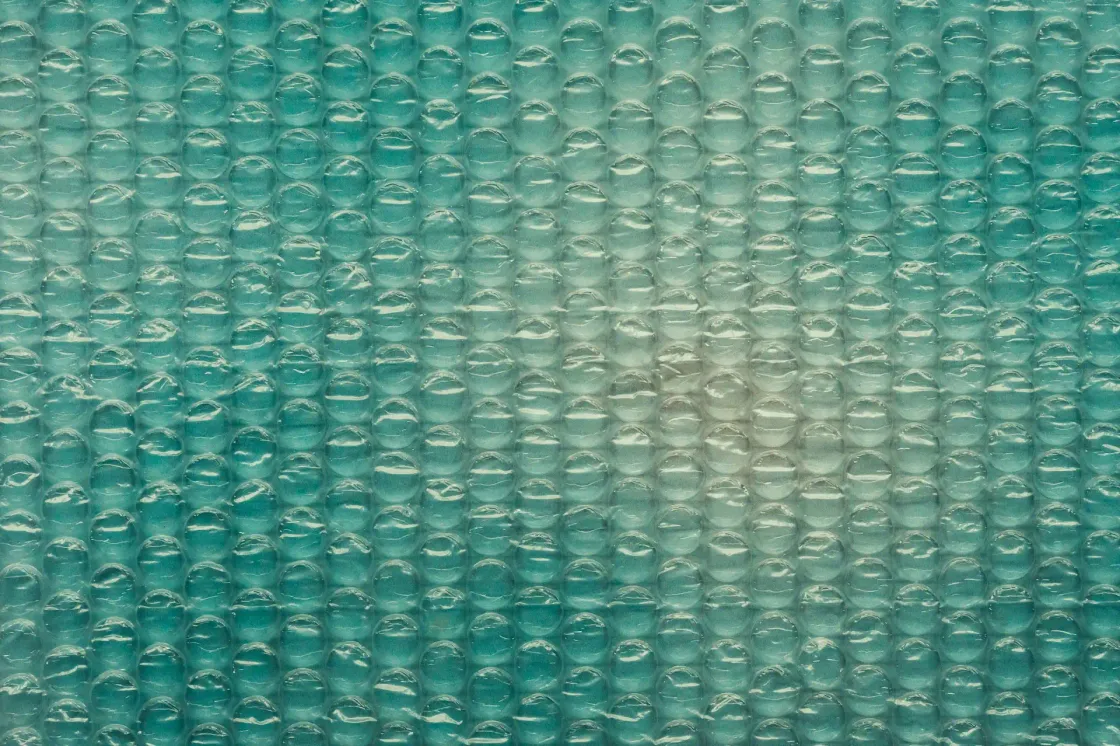 Close up of teal bubble wrap texture representing protection and stability in a fast changing, AI driven workplace.