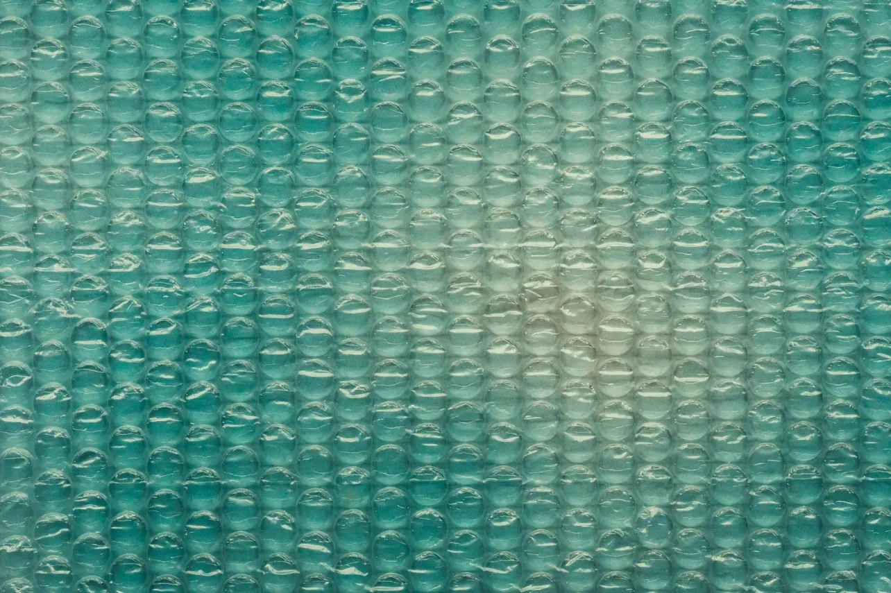 Close up of teal bubble wrap texture representing protection and stability in a fast changing, AI driven workplace.